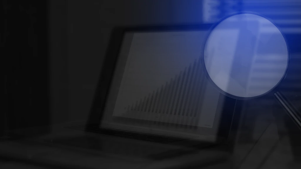 Lupa sobre um computador com gráficos para montar um setor comercial